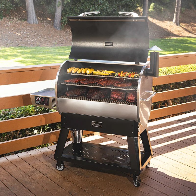 recteq Flagship 1600 pellet grill with the lid open, ribs and vegetables cooking on the grates, on an outdoor deck